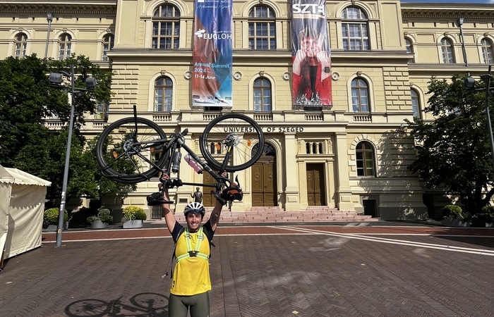 Cyclist lifting bike above head